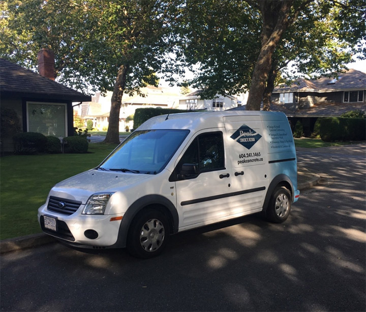 A white van with the Peak Concrete logo on a residential street
